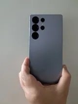 Rear of a Samsung Galaxy S25 Ultra in titanium silver blue, held in one hand