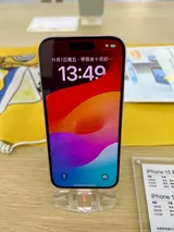 Apple iPhone 15, front view on a display stand showing its lock screen