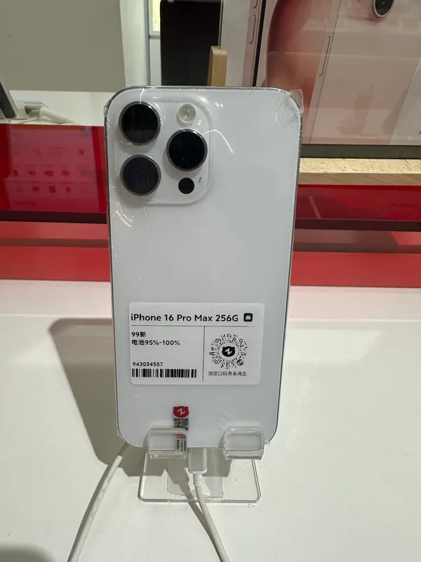 Apple iPhone 16 Pro Max in white titanium, rear view on a display stand