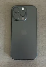 Rear of a black Apple iPhone 16 Pro lying on a table, showing its triple camera