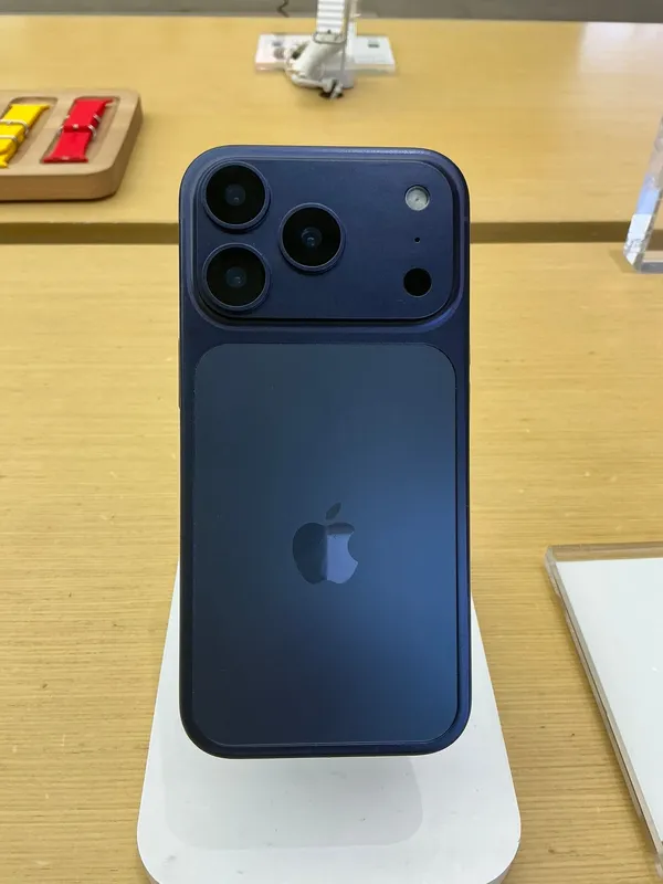 Apple iPhone 17 Pro in deep blue, rear view on a display stand
